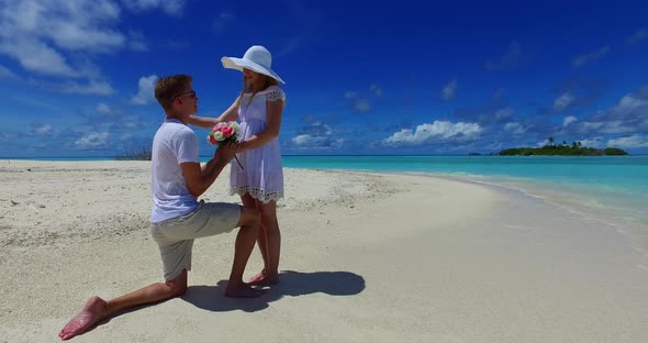 Beautiful man and woman on romantic honeymoon live the dream on beach on summer white sandy 