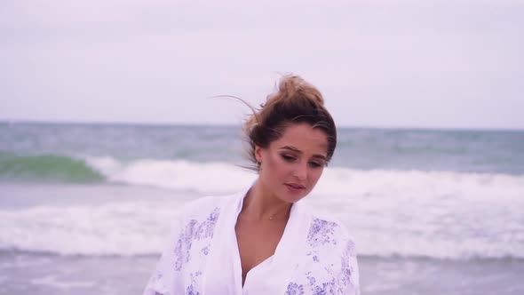 Girl Walks on the Beach on the Background of the Sea