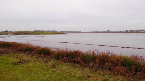 Aerial Low Flying Over Flood Plain Beside Noord In Ridderkerk With Birds Flying Past