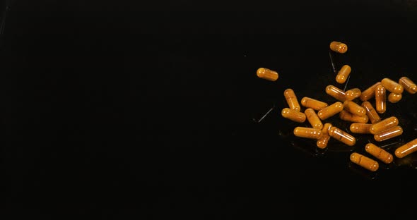 Turmeric, Turmeric Longa, Capsules Falling on Black Background, Indian Spice, Slow Motion 4K