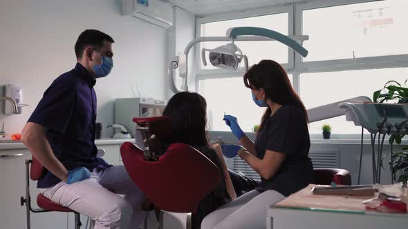 Professional Woman Dentist in Medical Gloves Examines Patient in Dental Clinic