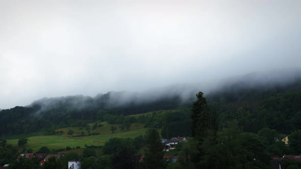 Clouds moving fast over mountains in dusk.