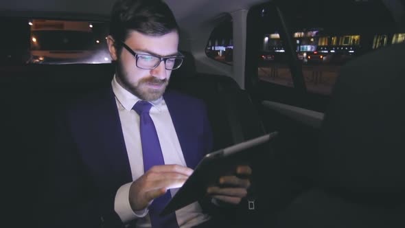 Businessman with tablet in car