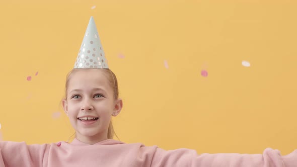 Girl in Party Hat Throwing Confetti