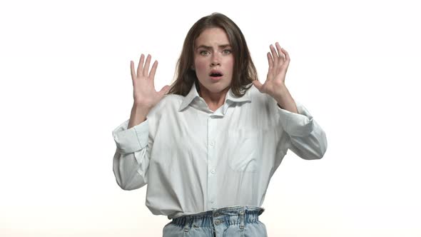 Video of Attractive Young Brunette Woman in White Shirt Gasping Startled Standing Ambushed Against