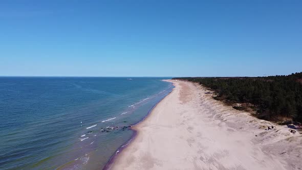 Wild coastline of Baltic sea with blue sky, aerial drone view