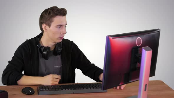 Nervous Man Watching Video Games on a PC Computer on Gradient Background.
