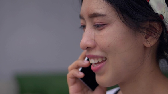 Close Up Portrait of young Asian woman talking on phone smiling and happiness.