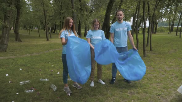 Positive Confident Volunteers Opening Garbage Bags and Start Park Cleanup on Summer Day, Wide Shot