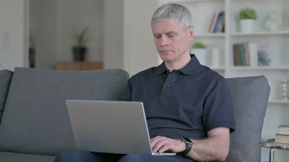 Middle Aged Man Working on Laptop