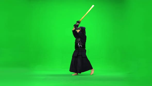 Masculine Kendo Warrior Practicing Martial Art with the Bamboo Bokken on Green Screen.