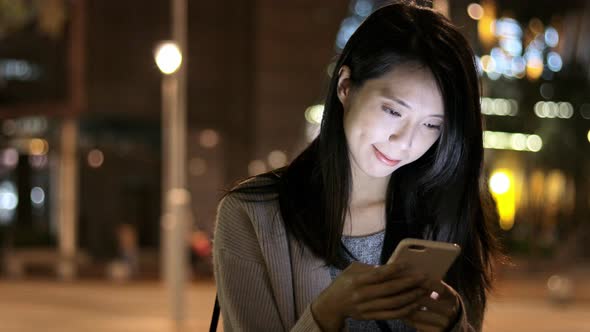 Woman watching on cellphone at night 