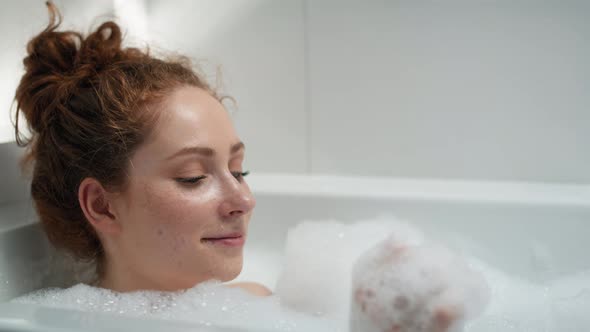 Caucasian redhead woman taking a bath. Shot with RED helium camera in 4K.