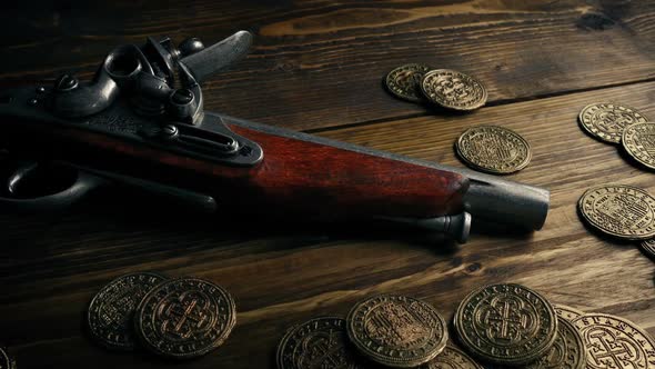 Historic Gun With Gold Coins On Table