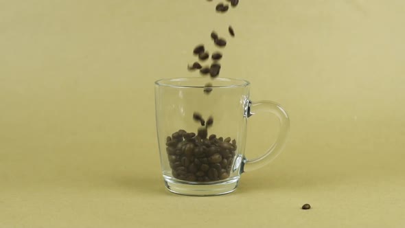 Coffee Beans Quickly Fly, Clear Glass Mug, Beige Background. Energy Concept