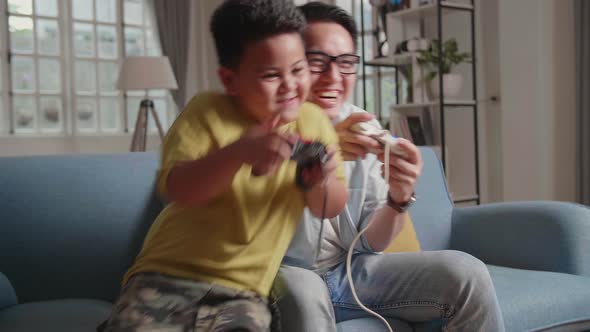 Asian Man And Son Are Fighting Each Other While Playing A Game, Joking Each Other, Feeling Fun