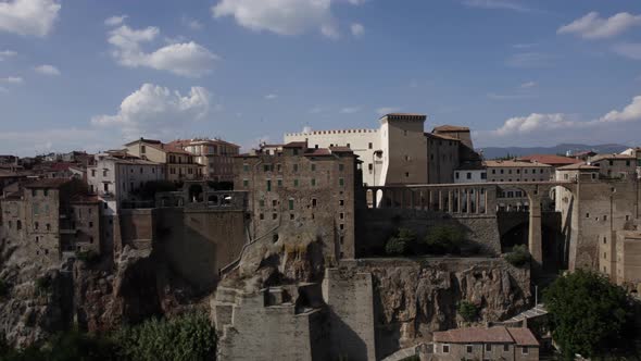 -SHOT: slider, side-DESCRIPTION: drone video over the side of Pitigliano, Italy-HOUR.WEATHER: summ