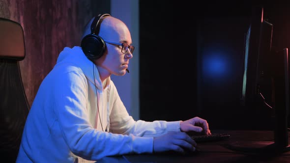 Young Male Gamer Playing Online Game on Pc Computer and Talking with Friends Online