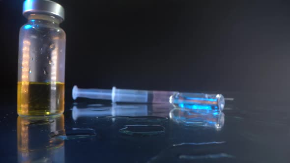 A Syringe with a Needle with a Collected Drug From the Virus on a Glass Surface. the Used Ampoule