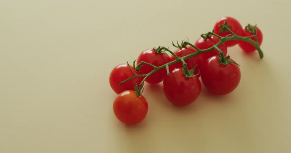 Video of fresh cherry tomatoes with copy space on yellow background