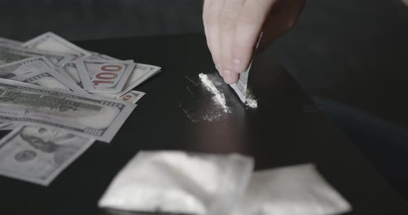 Young Addicted Man Taking Cocaine with Dollar