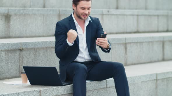 Business Man Talking on Smartphone at Street. Manager Reading Good News on Phone