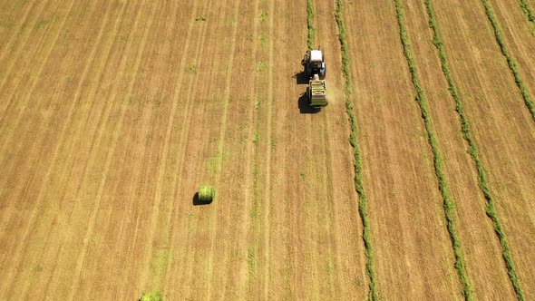 Tractor harvesting grass on the farmland