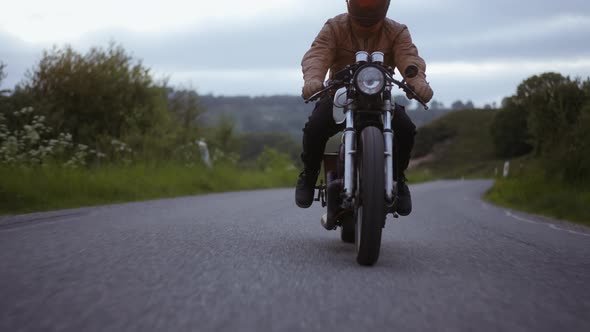 Tracking Shot of Motorcycle Smoothly Driven on the Road Surrounded By Trees alt