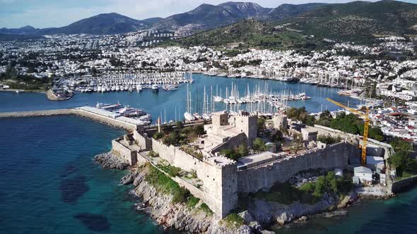 View from drone on full of yachts Bodrum harbour and ancient Kalesi castle in Mugla in Turkey