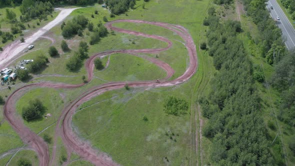 Motorcyclist on motocross bike riding on winding off road track training for competition