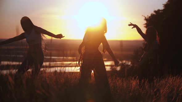 Three Young Women Slowly Dancing on Sunset