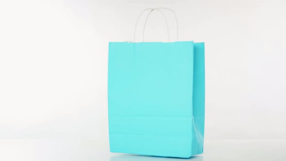 Blue Recycled Paper Bag with Goods Falls on the Table