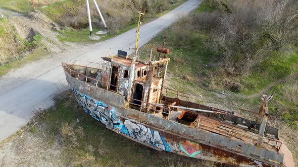 Drone flies over an old rusty ship