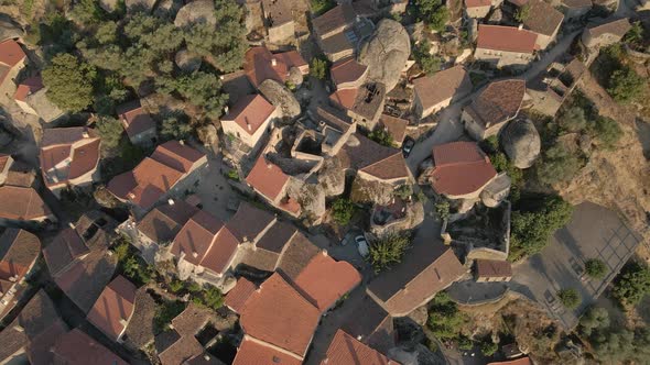 Monsanto castle ruins and village at sunset, Portugal. Aerial tilt-up reveal backward