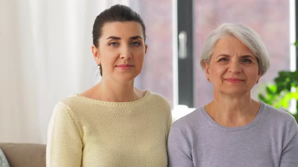 Senior Mother with Adult Daughter Hugging at Home