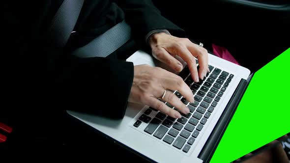 Businesswoman sitting in car and using laptop