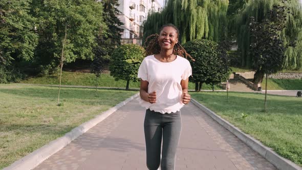 Young Active African American Woman Jogging in Park To Keep Healthy