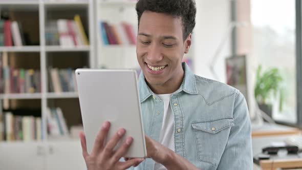 Smiling Young African American Man Using Digital Tablet