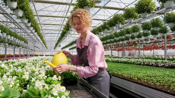 Cheerful Womens Watering Flowers From a Watering Can