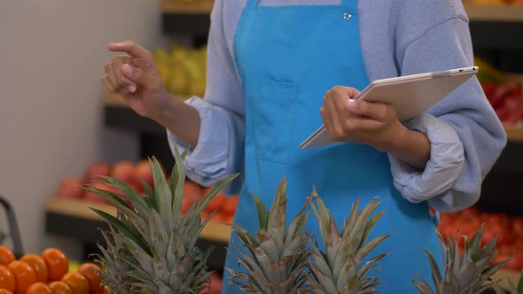 Female Grocery Store Staff with Tablet During Work