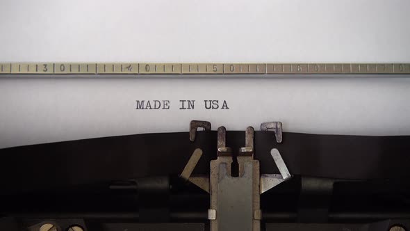 Typing phrase MADE IN USA on retro typewriter. Close up.
