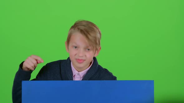 Child Boy Appeared From Behind a Blue Poster To Look at Him Shows Like Hiding Again. Green Screen