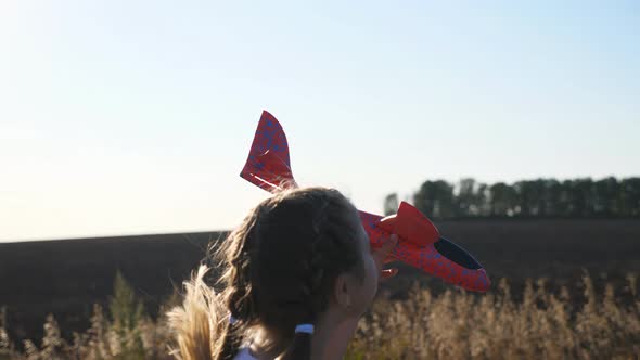 Carefree Little Child Holds in Hand Toy Plane Jogging Against the Sunlight at Background