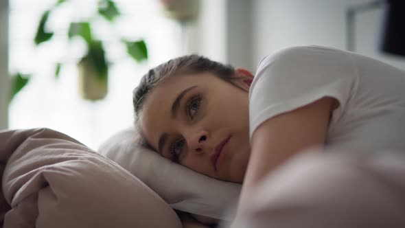 Close up video of depressed woman lying down in bed. Shot with RED helium camera in 8K.