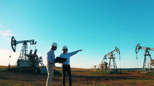 Two Engineers Inspecting Oil Field Equipment