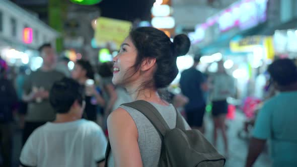 Beautiful female walking and eating street food at The Khao San Road.