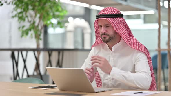 Pensive Arab Businessman Thinking and Working on Laptop