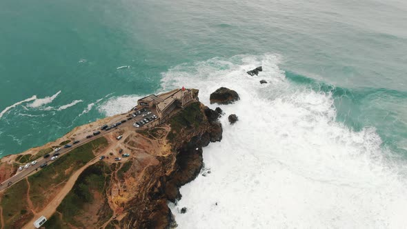 Lighthouse on Steep Cliff Near Ocean on Rainy Day Aerial