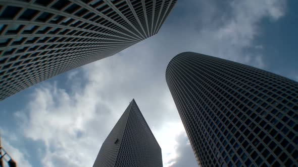 Time lapse of clouds from a low angle shot of skyscrapers in Tel Aviv