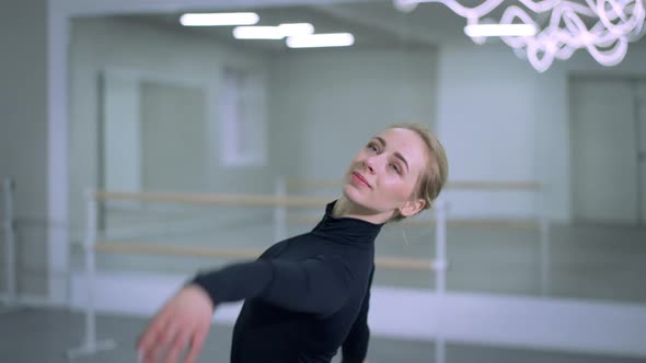 Beautiful Slim Ballerina Looking at Camera Dancing Indoors